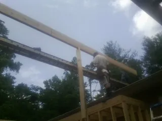 Carpenter setting a ridge beam over a new addition frame — Ice Dam Removal by Roofing Brothers in Vandalia