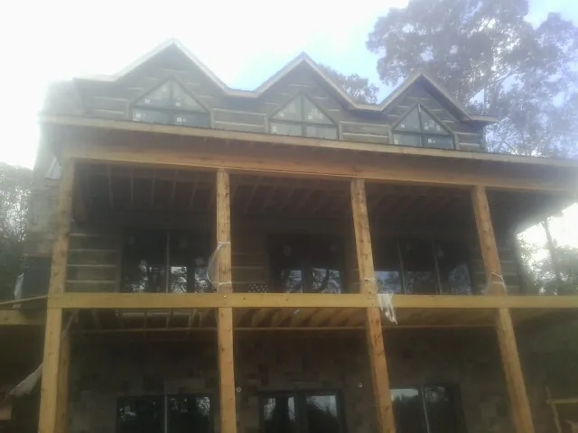 Dormers and porch framing on a large log home under construction — Roof Coating work by our crew in Vandalia